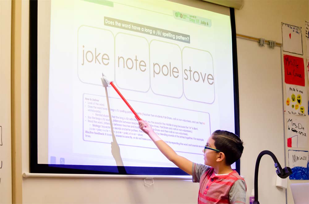Boy_Phonics_Whiteboard Boy pointing to the whiteboard