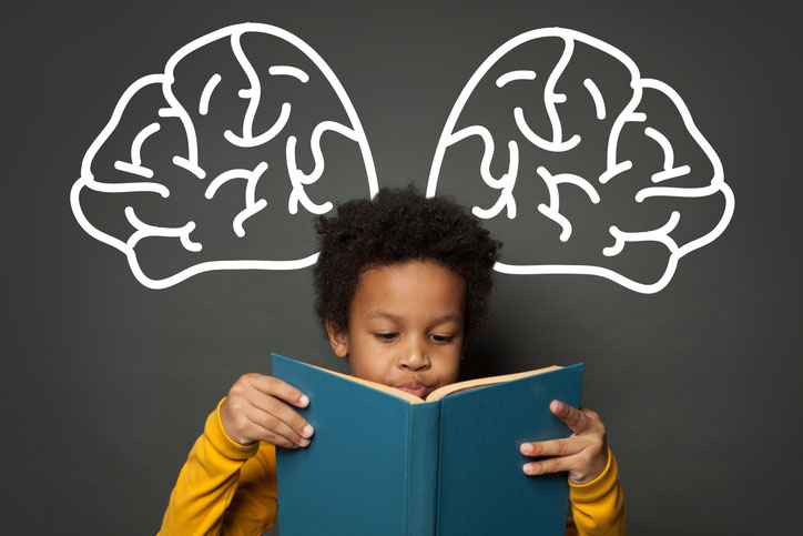 Child reading a book while emphasizing his brain